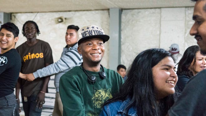 Haitian migrant Garry Clema is wearing a New York hat and singing with other migrants at Tijuana’s Casa del Migrante shelter for migrants, in Tijuana, Mexico, in October.
