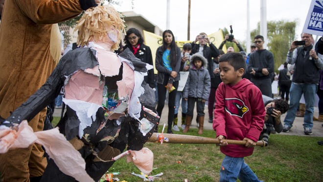 Dylan Moreno, 6, hits a piñata in the effigy of Donald Trump during a protest against Trump's inauguration as the 45th president of the United States at the Arizona state Capitol in Phoenix on Jan. 20, 2017. Trump's election to the presidency has sparked protests since Election Day.