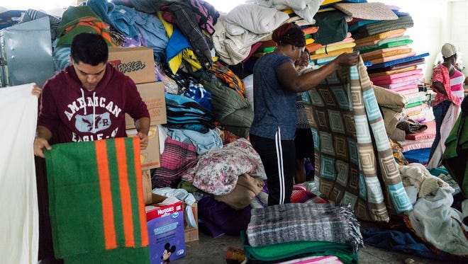Haitian and Central American migrants put away their blankets after they wake up one October morning at Desayunador Salesiano Padre Chava, a shelter in Tijuana, Mexico.