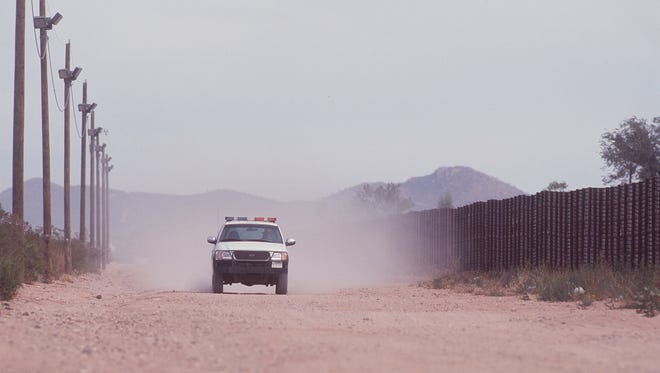 A U.S. Border Patrol agent guards the U.S. side of the border fence in Douglas.