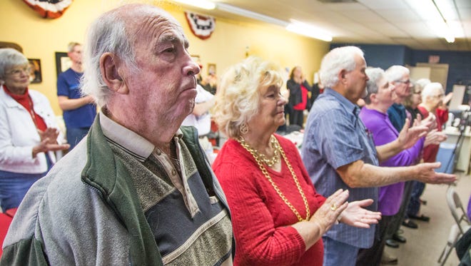 Donald Trump supporters Warren Clucker (from left), 79; his wife, Patricia, 78; and Gary Cotton, 68, are among those who packed the Arizona Republican Party office in Sun City to watch the inauguration of the 45th president of the United States via a live television feed on Jan. 20, 2017.