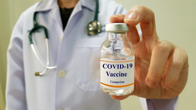 Un doctor sostiene en su mano una ampolleta, de la vacuna contra COVID-19.