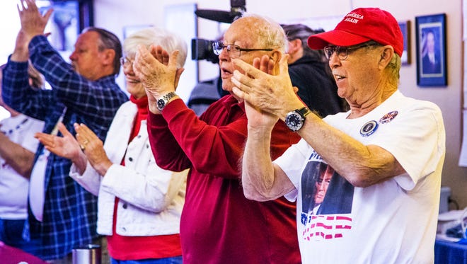 Donald Trump supporters Tom Scanlan (from right), 78, Sun City; and Stan Lyons, 81, Sun City West, and others applaud at the Arizona Republican Party office in Sun City after watching the inauguration of the 45th president of the United States via a live television feed.
