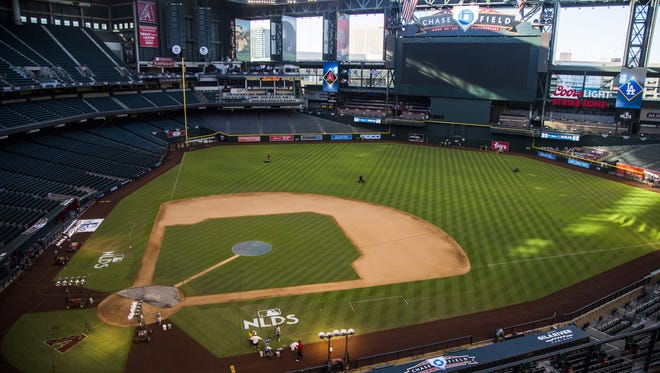 The field gets freshly cut as paint is applied to new NLDS logos the day before Game 3 at Chase Field in Phoenix, Ariz. on October 8, 2017.