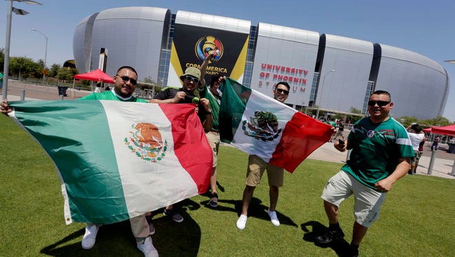 Archivo -- Fanáticos del ‘Tri’ ondean banderas mexicanas afuera del estadio de Glendale, Arizona.