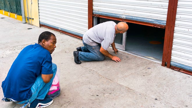 A Haitian migrant peers under the door of Desayunador Salesiano Padre Chava, a shelter for migrants in Tijuana. The shelter was closed and the man had knocked on the door hoping to get some food.