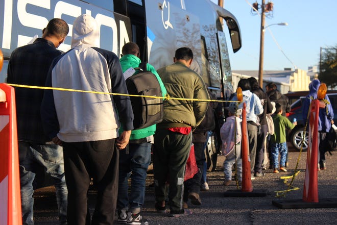 Migrants board a bus behind the Pimeria Alta Historical Society Museum in Nogales after being dropped off by Border Patrol on Dec. 14, 2023.