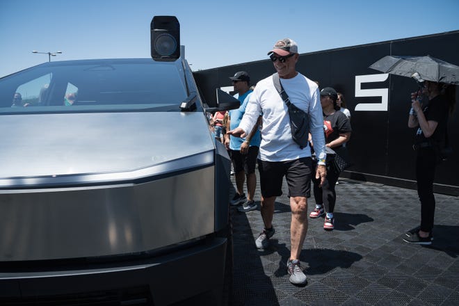 Michael Carneal takes a close-up look at the Tesla Cybertruck at the Electrify Expo outside State Farm Stadium on May 4, 2024 in Glendale, Ariz. Michael has been on a waiting list for a different model of the Cybertruck for multiple years.