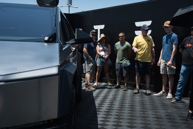 People wait in line for a closer look inside the Tesla Cybertruck on display at the Electrify Expo outside State Farm Stadium on May 4, 2024 in Glendale, Ariz.