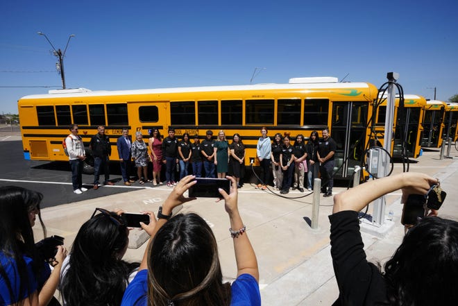 Mayor Kate Gallego takes photos with Isaac Middle School students in front of the new buses during a news conference and ride along for the new electric school bus in Phoenix on May 7, 2024.