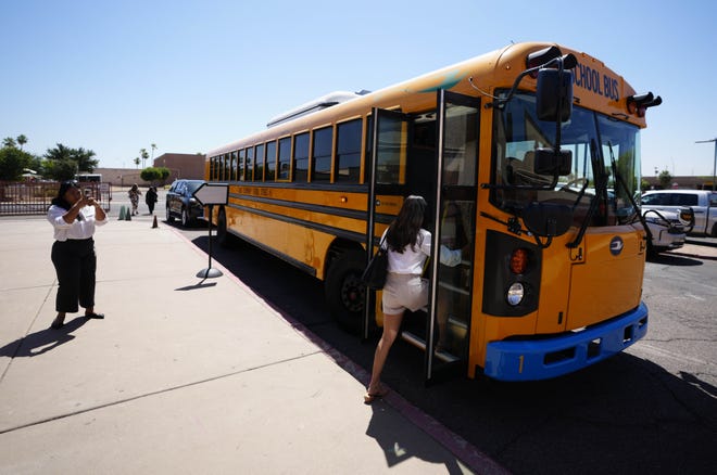 Guests load onto the new electric bus at Isaac Middle School during a news conference and ride-along for the new electric school bus in Phoenix on May 7, 2024.