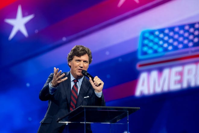 Tucker Carlson speaks as conservative leaders and personalities attend Turning Point USA's AmericaFest 2023 in Phoenix on Dec. 18, 2023.