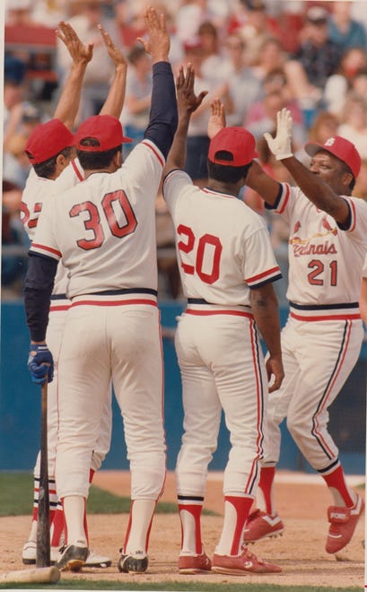 St. Louis Cardinals player Curt Flood is greeted at home plate by Julian Javier, Orlando Cepeda, and Lou Brock after hitting a second inning three-run homer during Dream game ‘89 during spring training Feb. 19, 1989.