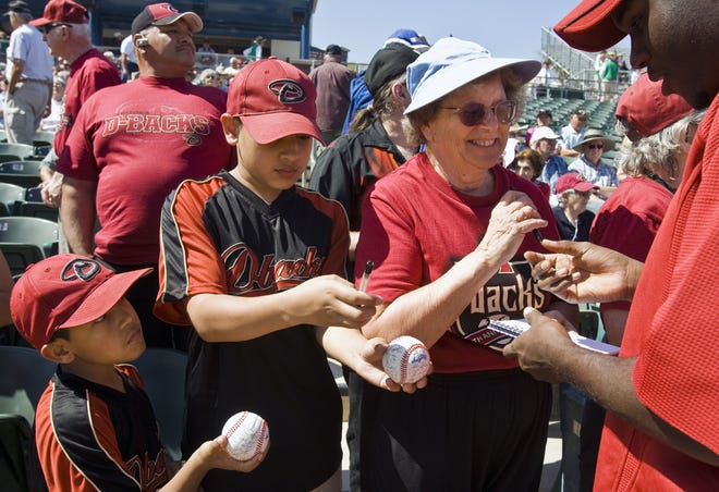 Memo Lugo, 7, his brother Mark Lugo, 12, and Jackie Janesky, all of Tucson, gather autographs from new Diamondbacks pitcher Edwin Jackson at Tucson Electric Park on March 4, 2010.