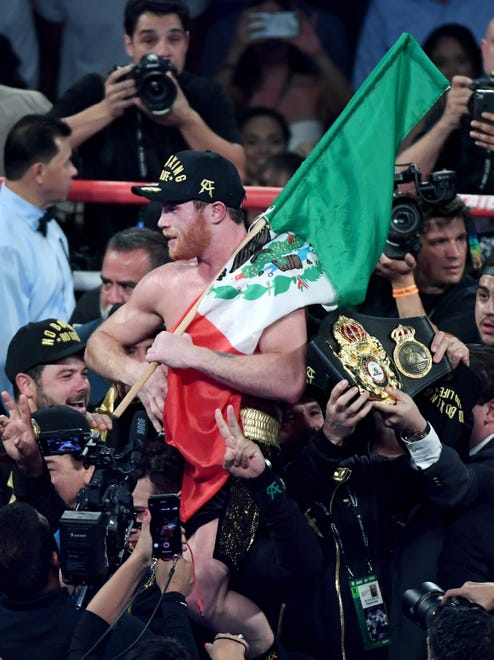 Saúl ‘Canelo’ Álvarez celebra el triunfo con la bandera mexicana.
