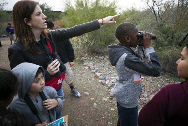 Emily Martell, a teacher/naturalist with the Nina Mason Pulliam Rio Salado Audubon Center, points to a bird while bird-watching with kids from the Tri-City West Thornwood Branch of Avondale of the Boys & Girls Clubs of Metro Phoenix, on Dec. 6, 2018.