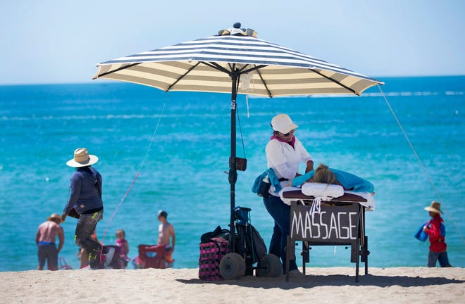 Jan Kortsen, de Thatcher, Arizona, recibe un masaje de Connie Clemente en Sandy Beach en Puerto Peñasco, México.