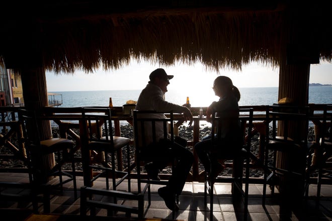 Orlando Cruz y Daniela Celaya, de Tucson, disfrutan de una bebida por la tarde en BooBar Cantina en el Malecón de Puerto Penasco, México.