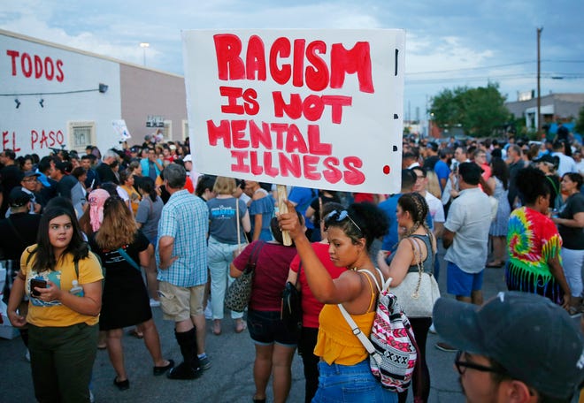 A woman holds a sign after a silent march to Las Americas Immigrant Advocacy Center for the victims of the Walmart shootings in El Paso August 4, 2019. Twenty people were killed and more than two dozen were injured in a mass shooting at Walmart on Saturday.