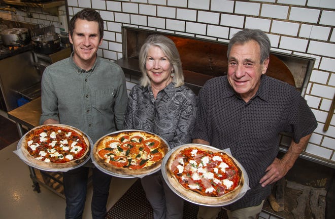 Aric Mei (left), owner of The Parlor, his mother and father Barbara and Danny Mei, owners of Nello's of Ahwatukee, show off delicious pizzas at The Parlor on Nov. 14, 2019.