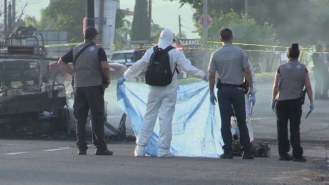 Personal forense en México identifica cuerpos en una zona de accidente. Foto archivo.