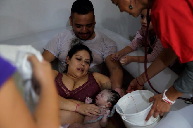 Selene Barragán (c), ayudada por su esposo Eduardo Castillo (d), pare en su casa ayer martes, en Guadalajara, en el estado de Jalisco (México).