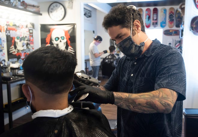 Jason Taylor, el due ñ o de East Hill Barbershop, vuelve a cortar el cabello en su barber í a de la Avenida 12, el lunes 11 de mayo de 2020.
