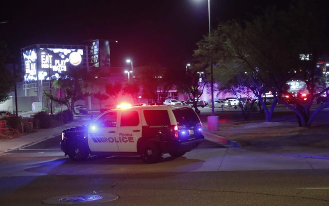 Un auto de la policía de Peoria bloquea una entrada al Westgate Entertainment District en Glendale. Al menos tres personas fueron baleadas el miércoles, según la policía de Glendale. La policía dijo que al menos una persona estaba detenida en relación con el tiroteo.