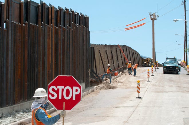 Fotografía de archivo de unos trabajadores finalizan un trozo del muro fronterizo que separa México de Estados Unidos en el paso de Deconcini en Nogales (Arizona).