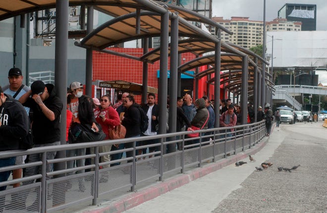 Cientos de personas hacen fila intentando cruzar hacia Estados Unidos en la frontera con México, en la ciudad de Tijuana en Baja California, (México).
