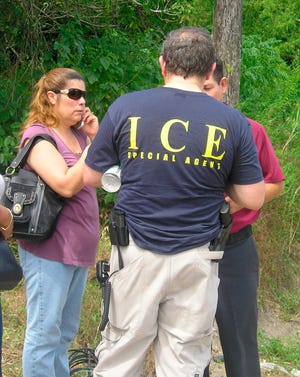 Un agente del Servicio de Inmigración y Aduanas (ICE) conversa con varias personas.