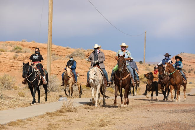 Diné advocate Allie Young (far left) rides to the polls alongside several Navajo voters on horseback near Agathla Peak, which is north of Kayenta, on Election Day. Young started the Ride to the Polls Initiative in an effort to encourage more Navajo voters to get out and vote.