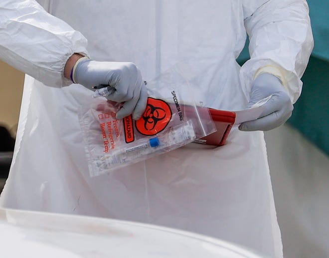 Un hisopo de prueba es colocado en una bolsa de muestras de riesgo biológico en un lugar de prueba para los trabajadores de la salud y los socorristas que creen que pueden haber estado en contacto con un portador del coronavirus SARS-CoV-2 que causa la enfermedad Covid-19. en Northlake, Illinois.