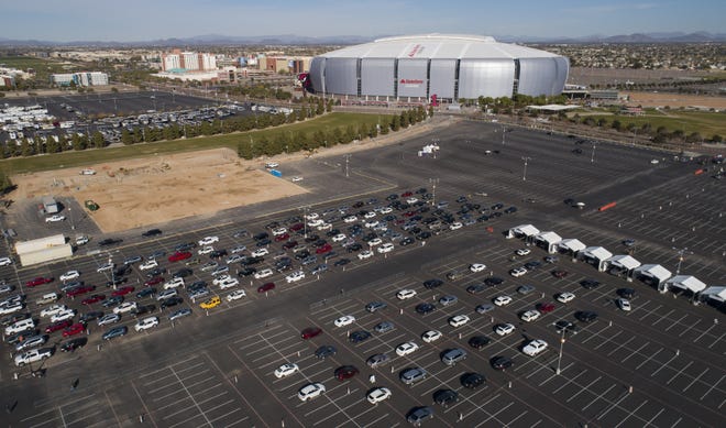 Cars line up at Arizona's first 24/7 COVID-19 vaccination site at State Farm Stadium in Glendale on Jan. 12, 2021.