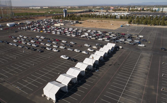 Cars line up at Arizona's first 24/7 COVID-19 vaccination site at State Farm Stadium in Glendale on Jan. 12, 2021.