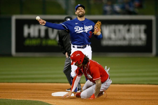 Los Angeles Dodgers second baseman Chris Taylor (3) throws over Jonathan India to complete a double play on a ground ball off the bat of Cheslor Cuthbert in the fourth inning of the MLB Cactus League Spring Training game between the Los Angeles Dodgers and the Cincinnati Reds at Camelback Ranch in Glendale, Ariz., on Wednesday, March 3, 2021. The game, scheduled for seven innings, was tied at 2 in the fifth inning.