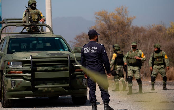 ARCHIVO -- Miembros del ejército y la policía montan guardia en la zona de un accidente en Mexico.