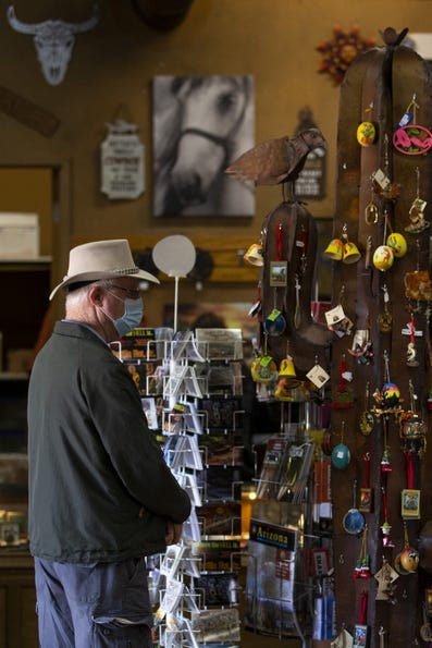 Un turista mira artículos a la venta en la tienda de regalos en Tortilla Flat el 26 de febrero de 2021.