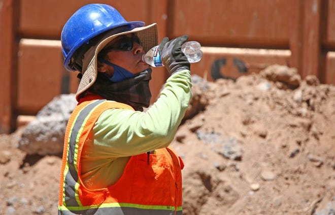 Un trabajador de la construcción bebe agua para mantenerse hidratado en Phoenix el 16 de junio de 2020.