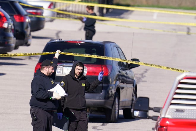 Authorities confer at the scene where multiple people were shot at the FedEx Ground facility early Friday morning, April 16, 2021, in Indianapolis. A gunman killed eight people and wounded several others before apparently taking his own life in a late-night attack at a FedEx facility near the Indianapolis airport, police said, in the latest in a spate of mass shootings in the United States after a relative lull during the pandemic. (AP Photo/Michael Conroy)