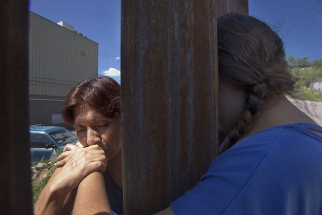 Adriana Gil Diaz, right, hugs her mother, Maria Antonia Diaz, from the U.S. side of the border at Nogales.