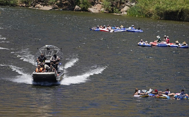 An emergency response boat passes tubers on the lower Salt River on May 29, 2021.