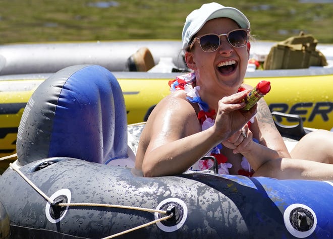 Samantha Spooner, 26, of Tucson, squirts her friends with water while tubing at the Salt River on May 29, 2021.