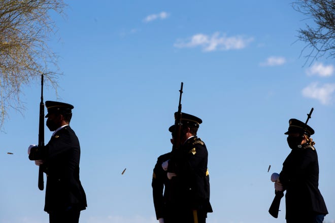 An honor guard fires the three-volley salute for Memorial Day at the National Memorial Cemetery of Arizona in Phoenix on May 31, 2021.