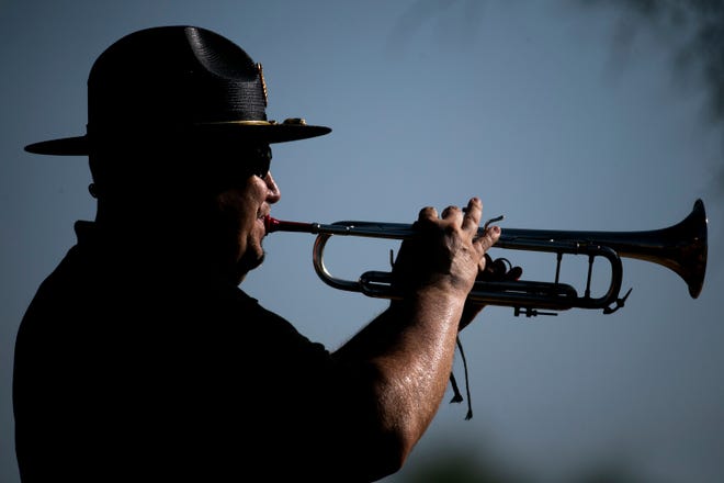 Bugler David Bonczkiewicz plays with the honor guard on Memorial Day at the National Memorial Cemetery of Arizona in Phoenix on May 31, 2021.