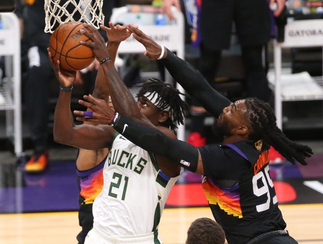 Milwaukee Bucks guard Jrue Holiday (21) grabs a rebound from Phoenix Suns forward Jae Crowder (99) during Game 2 of the NBA Finals at Phoenix Suns Arena July 8, 2021.