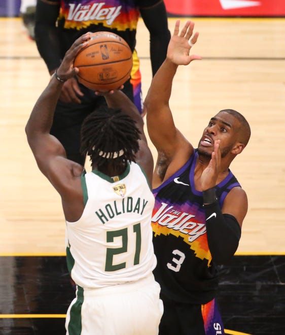 Phoenix Suns guard Chris Paul (3) defends against Milwaukee Bucks guard Jrue Holiday (21) during Game 2 of the NBA Finals at Phoenix Suns Arena July 8, 2021.