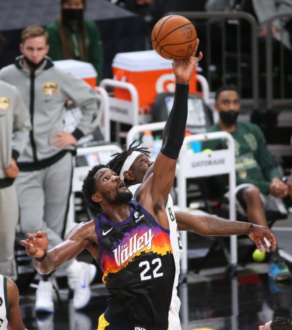 Phoenix Suns center Deandre Ayton (22) jumps ball with Milwaukee Bucks guard Jrue Holiday (21) during Game 2 of the NBA Finals at Phoenix Suns Arena July 8, 2021.