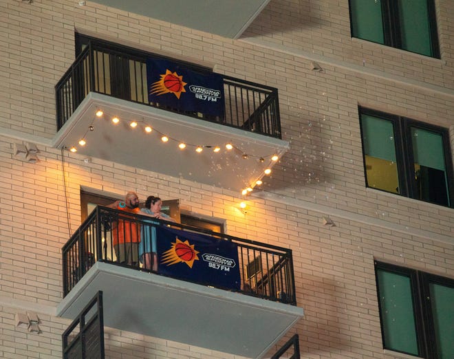 Fans release bubbles from a high-rise building to celebrate after the Suns beat the Milwaukee Bucks 118-108 in Game 2 of the NBA Finals outside the Phoenix Suns Arena in Phoenix on July 8, 2021.