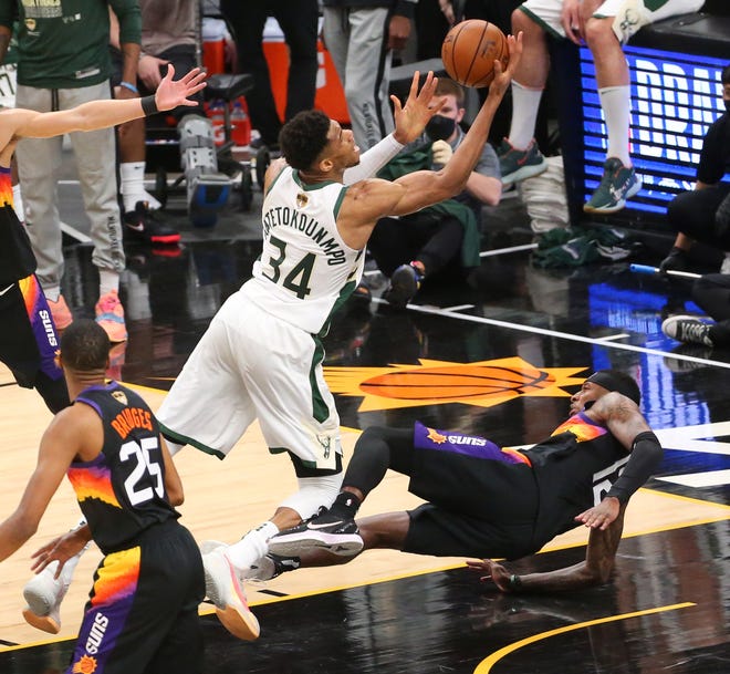 Phoenix Suns forward Torrey Craig (12) takes and offensive foul by Milwaukee Bucks forward Giannis Antetokounmpo (34) during Game 2 of the NBA Finals at Phoenix Suns Arena July 8, 2021.